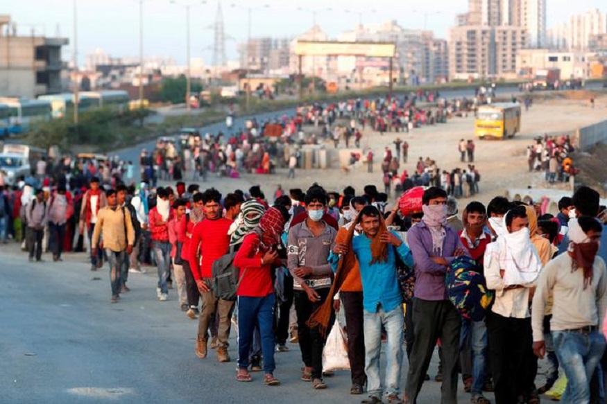 Migrant workers walk towards a bus station along a highway with their families as they return to their villages, during a 21-day nationwide lockdown to limit the spreading of coronavirus disease (COVID-19), in Ghaziabad